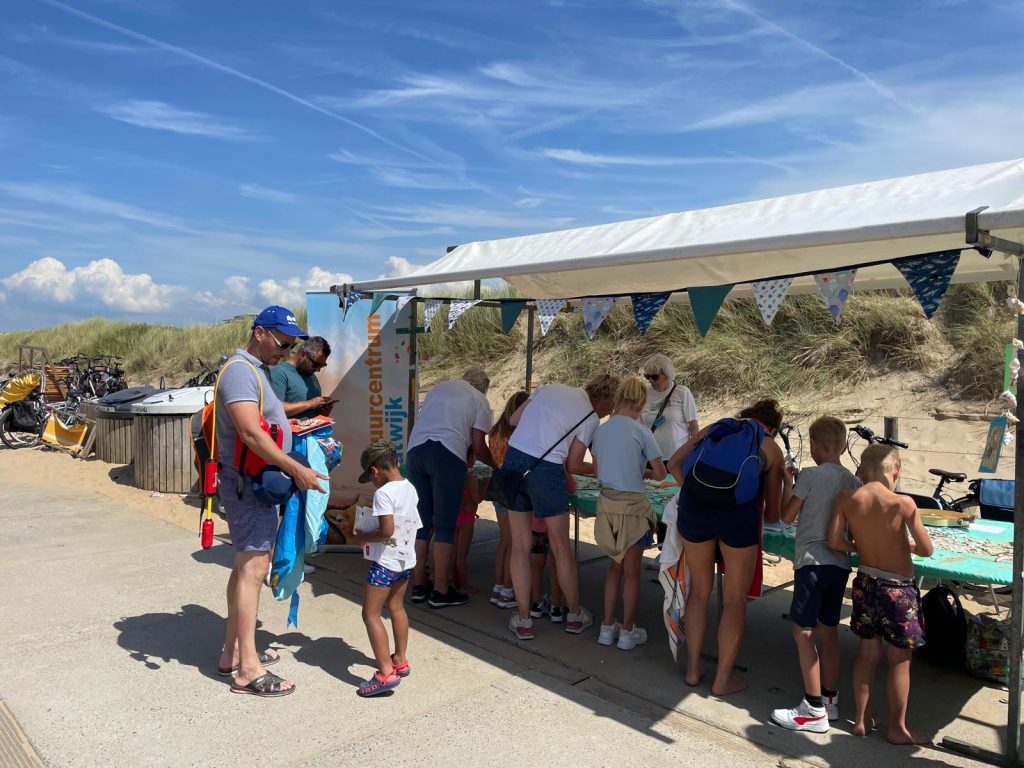Knutselen bij natuuractiviteiten Katwijk van Natuurcentrum Katwijk, met kinderen onder een tent in de duinen